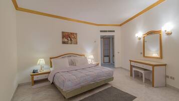 Un dormitorio con cama, mesitas de noche, un escritorio, un espejo y un cuadro en la pared.