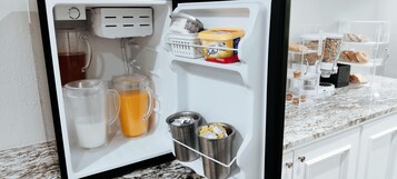 Un refrigerador con leche, jugo, mantequilla y cereal.