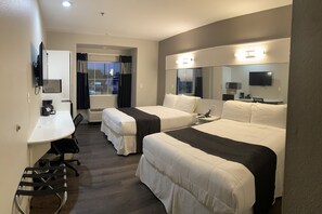 A hotel room with two single beds, a desk with a chair, a TV, a microwave, and a large mirror. - Crystal Inn (Port Arthur)