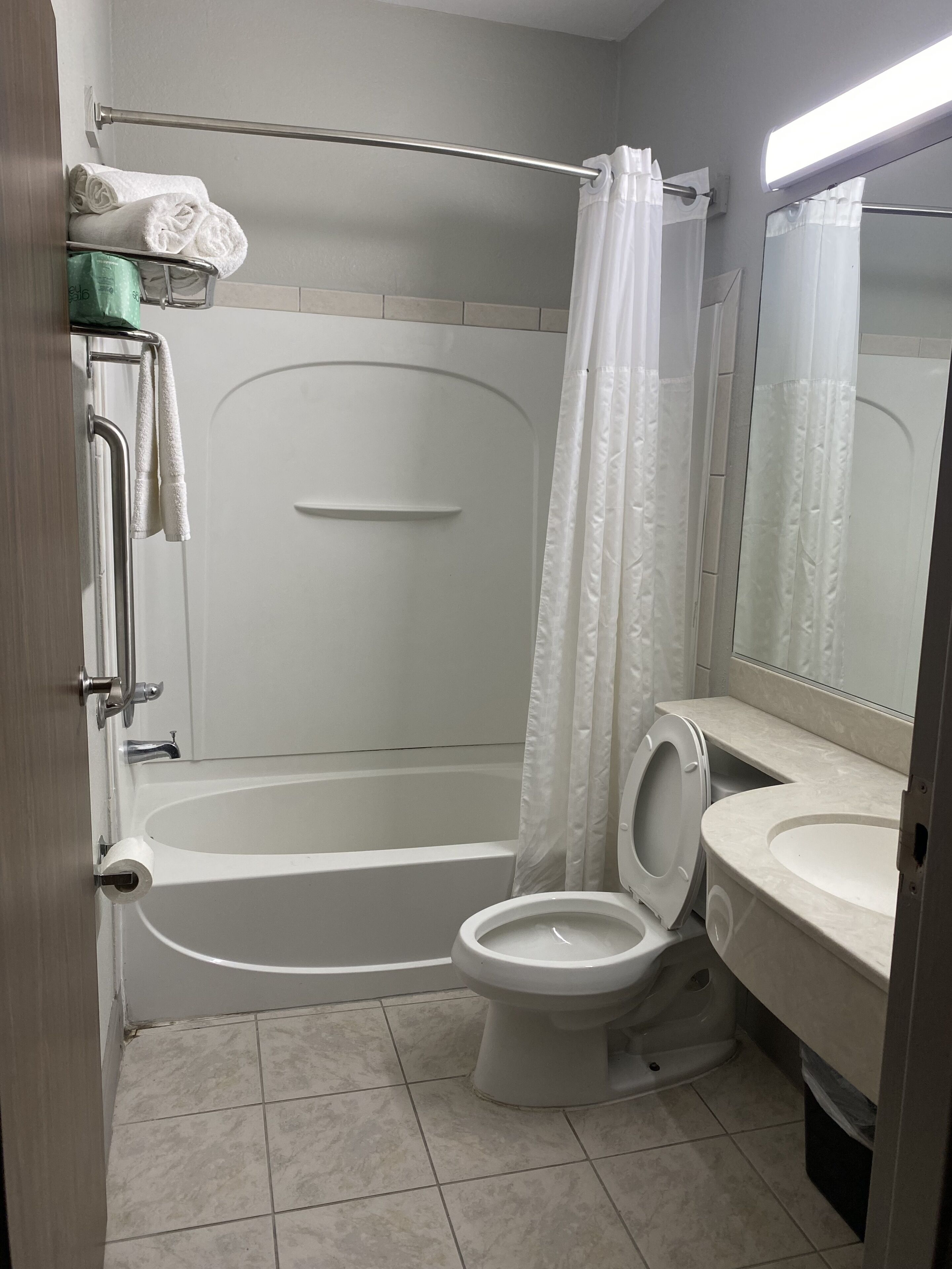 Une salle de bain avec une baignoire, des toilettes et un rideau de douche.