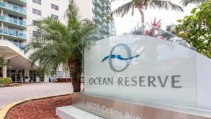 Indicador d'Ocean Reserve al carrer Collins, 19370, amb un edifici modern i una zona verda amb palmeres.