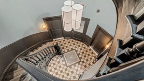 Eine Wendeltreppe mit Schachbrettmuster und einer modernen Leuchte.