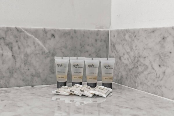 Un ensemble de cinq produits de la gamme « Novo », comprenant des shampooings et des produits aux parfums frais, disposés sur une surface en marbre.