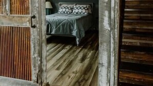 Une pièce rustique avec un lit, une porte en bois et une lanterne.