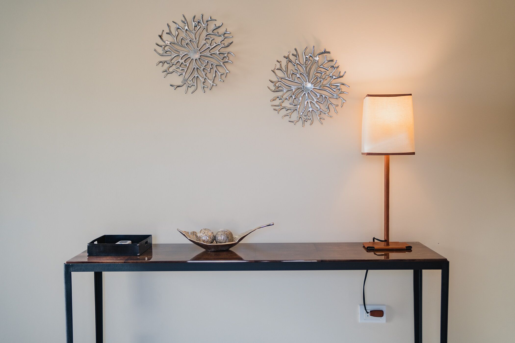 Ein Tisch mit Lampe und Wanddekoration.
