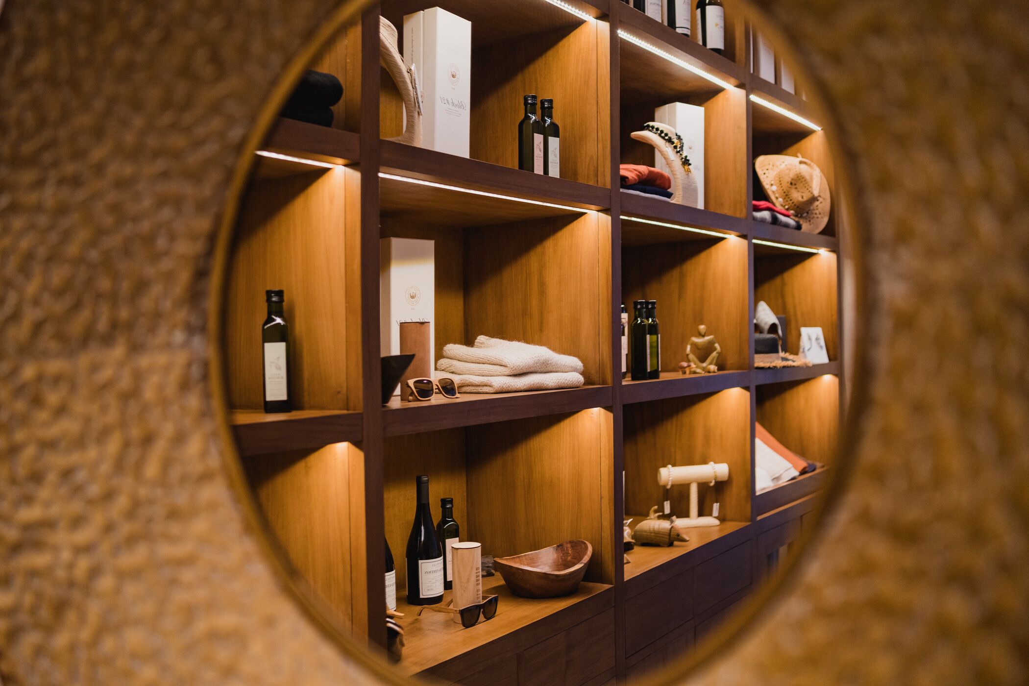 Une vue circulaire d’une étagère en bois sur laquelle sont disposés divers objets, notamment des bouteilles, des serviettes et des objets décoratifs.