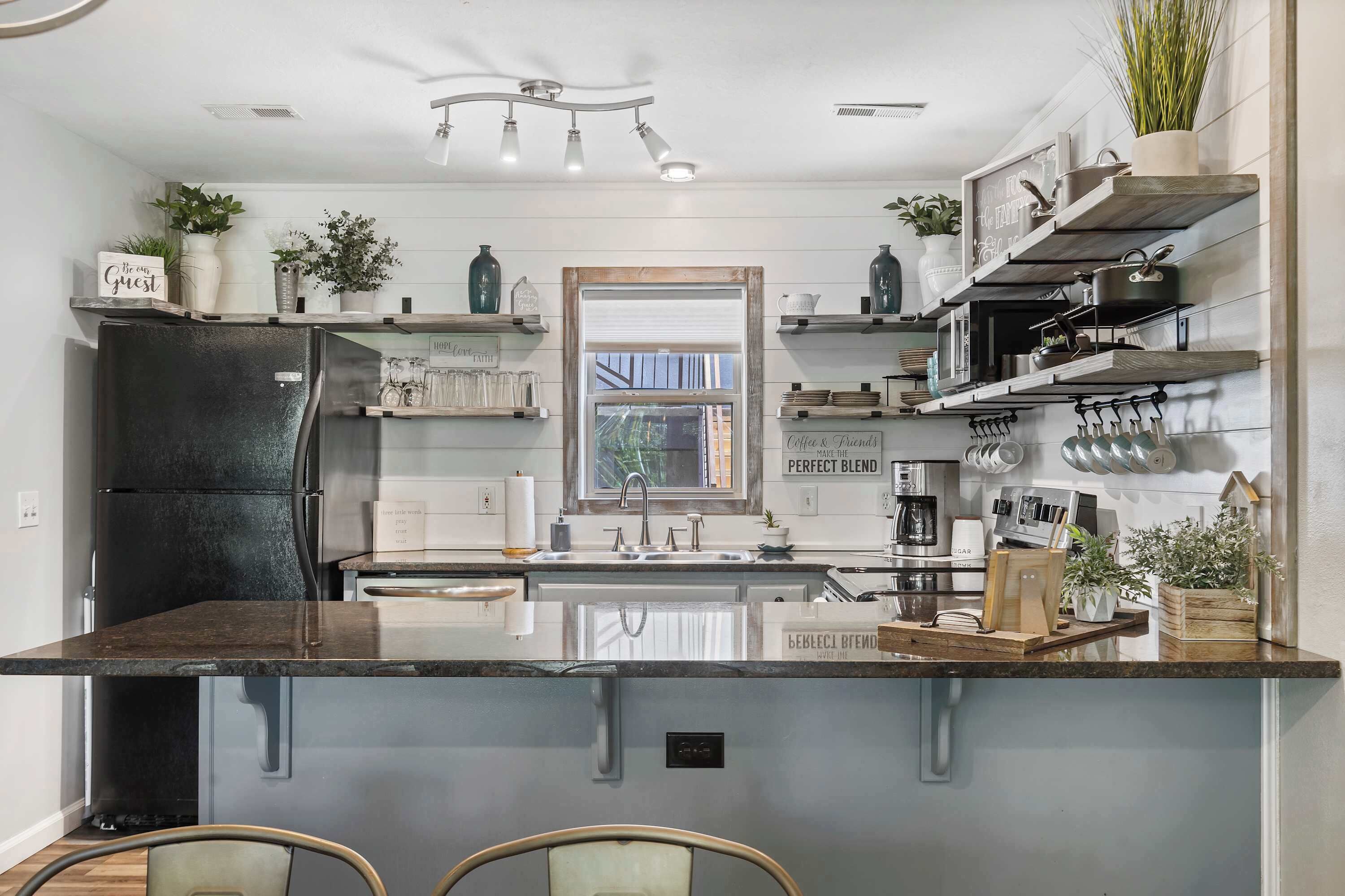A modern kitchen with a central island, built-in appliances, and decorative items.