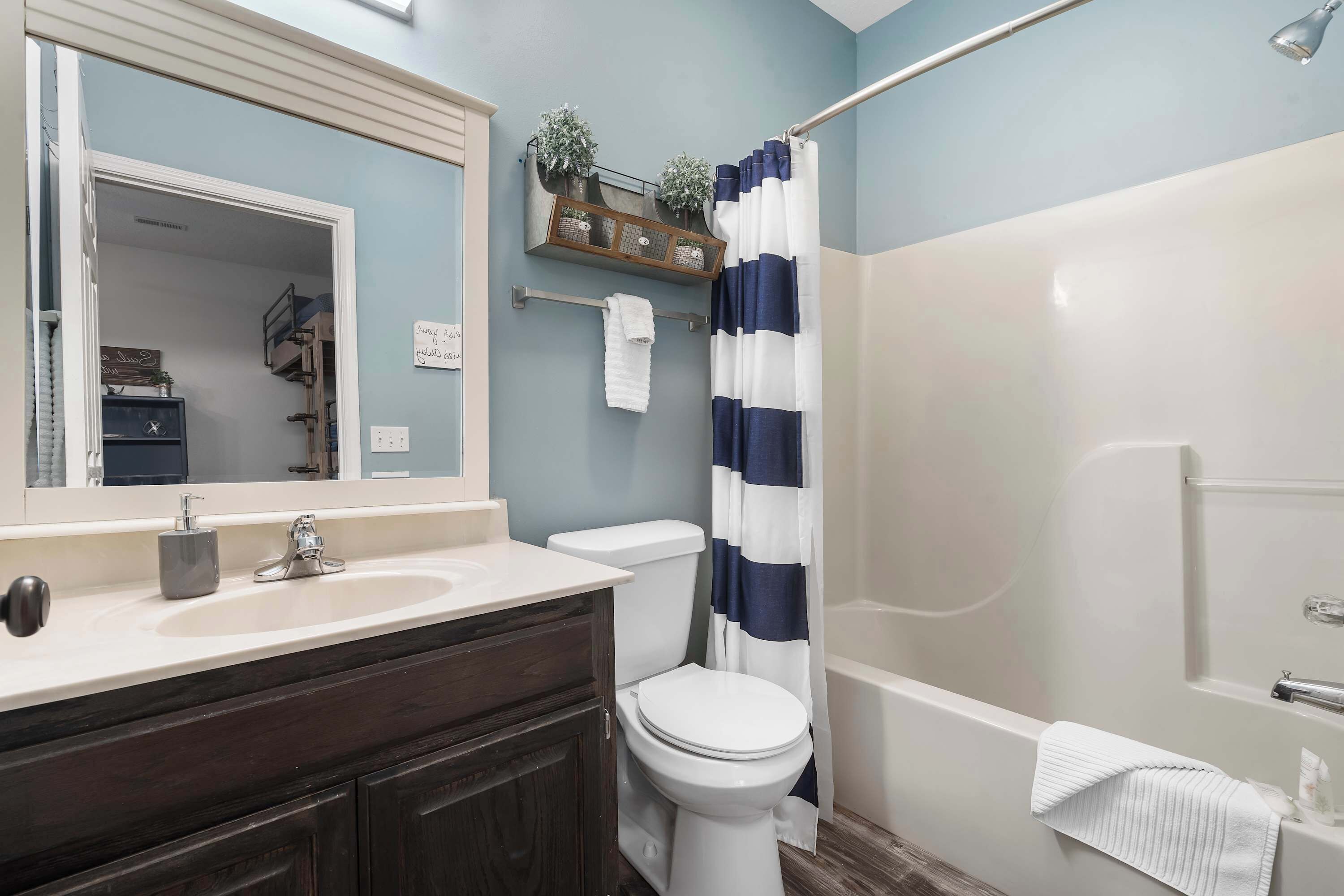 A bathroom with a white sink, a toilet, a bathtub, and a shower curtain.