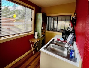 Enjoy cooking in this kitchen with a stainless steel sink, faucet, and coffee maker.