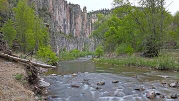 A river flowing through a canyon with rocky terrain and sparse vegetation.