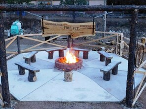 A fire pit with benches around it, labeled "Woodhenge Fire Pit Corral." - Lovely Suite at Lake Roberts (Lake Roberts)