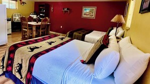 A hotel room with a bed, two bedside tables, a desk with a chair, a dining table with chairs, and a microwave. - Lovely Pet-Friendly Suite with Kitchen at Lake Roberts (Lake Roberts)