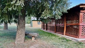 A wooden gazebo with lattice sides, a bench, and a tree in a park setting. - Lovely Pet-Friendly Suite with Kitchen at Lake Roberts (Lake Roberts)