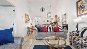 A living room with a grey sofa, a glass coffee table, and a patterned sofa. - Nantucket at the Pointe - Adventure & Relaxation! (Branson)