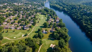 An aerial view of a residential area with houses, a golf course, and a river. - Wimbledon Pointe (Branson)