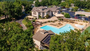 A large house with a swimming pool, surrounded by trees and a hilly landscape. - Wimbledon Pointe (Branson)