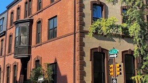 A corner building with a brick facade, a bay window, and a street sign indicating a one-way street. - Luxury 1BD Rittenhouse Sq. | Hosted By Stay Rafa (Philadelphia)