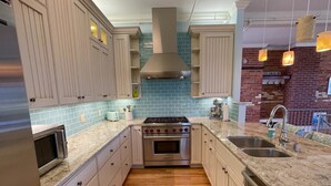 Une cuisine moderne avec des meubles en bois, un four en acier inoxydable et un plan de travail en granit.