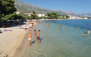 Guests can enjoy a serene beach experience with clear waters perfect for wading or swimming.
