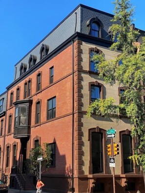 A multi-story building with a brick facade, large windows, and a corner entrance.