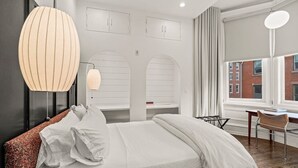 A modern hotel room with a large bed, a desk, and a view of the city. - Luxury 1BD Rittenhouse Sq. | Hosted By Stay Rafa (Philadelphia)
