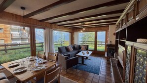 A cozy cabin interior with a dining area, sofa, and fireplace.