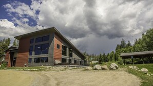 Un bâtiment moderne doté de grandes fenêtres et d’un espace extérieur abrité.