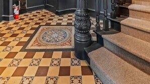 A grand staircase with a checkered floor and a patterned rug, leading to a dark door. - Luxury in Ritt Sq. | Parking | Hosted By StayRafa (Philadelphia)