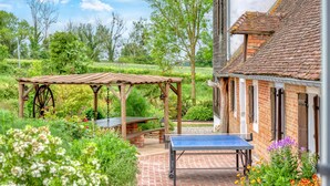 A garden with a ping pong table, wooden pergola, and a brick pathway. - Stunning home in Grandmesnil (Grandmesnil)