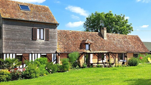 A traditional European-style house with a sloped roof, wooden siding, and a small window. - Stunning home in Grandmesnil (Grandmesnil)