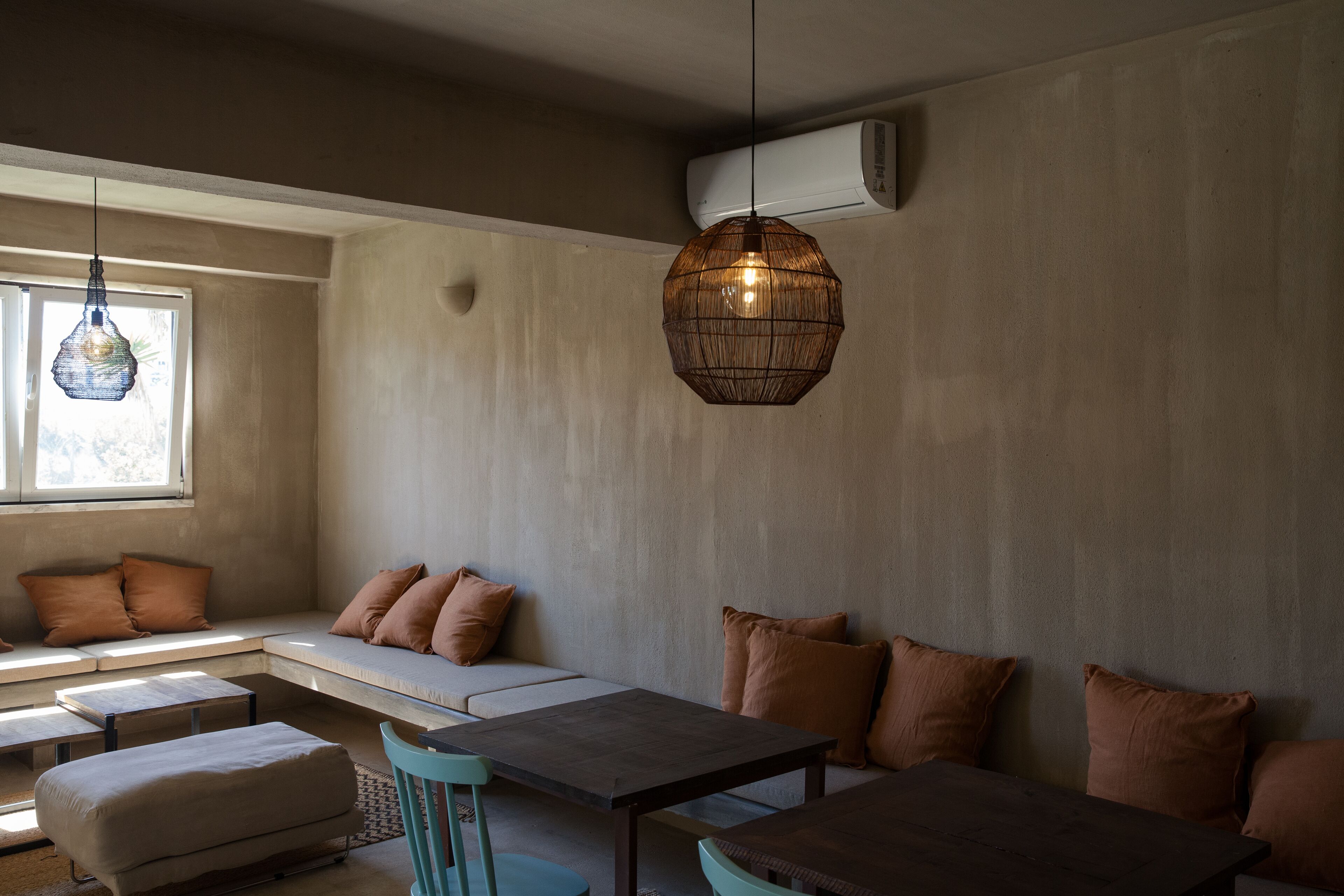 Una sala moderna con un sofá, una mesa de comedor y una lámpara colgante.