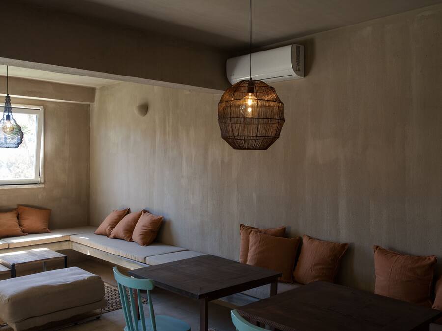 Una sala moderna con un sofá, una mesa de comedor y una lámpara colgante.