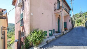 A narrow street with a pink building featuring a balcony, a green door, and potted plants. - Nice apartment in Camogli with WiFi (Camogli)