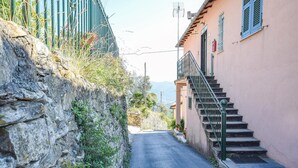 A narrow street with a stone wall on one side and a building with a staircase on the other. - Nice apartment in Camogli with WiFi (Camogli)