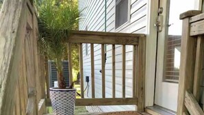 Une terrasse en bois avec une table ronde et des plantes en pot.