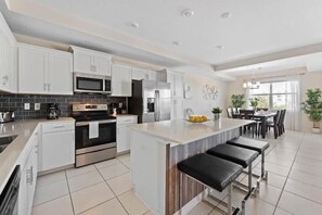 Enjoy cooking in this well-equipped kitchen with sleek cabinetry, stainless steel appliances, and a central island with bar seating.