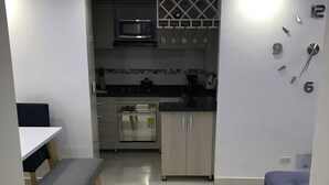 A modern kitchen with a microwave, oven, and a clock on the wall. - Amazing Condo with Pool - Magnífico Condo con Piscina (Yumbo)