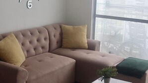 A modern living room with a sectional sofa, a black coffee table, and a wall clock. - Amazing Condo with Pool - Magnífico Condo con Piscina (Yumbo)