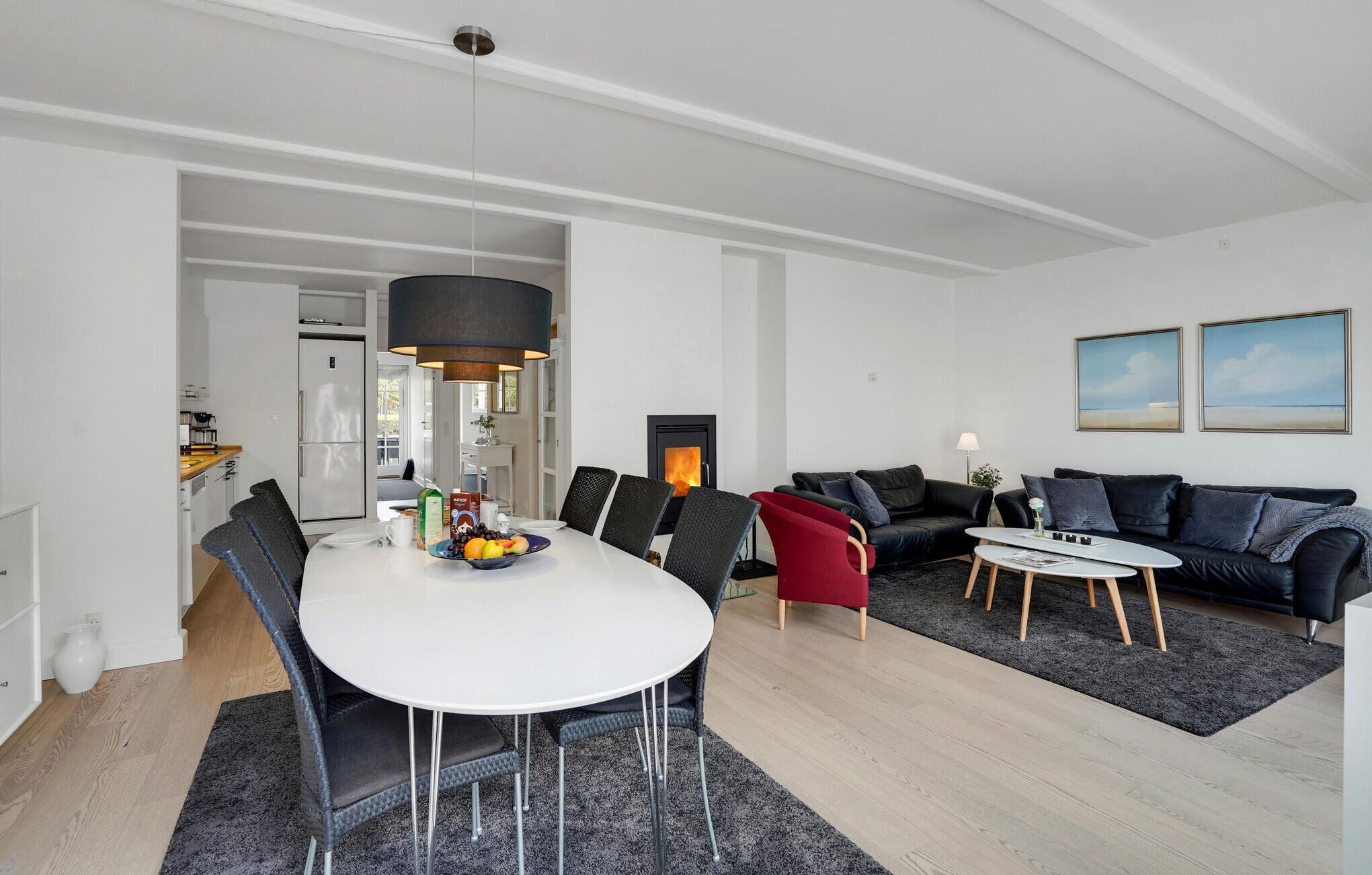 Un salon moderne comprenant un coin repas, une cheminée et un ensemble de canapés.