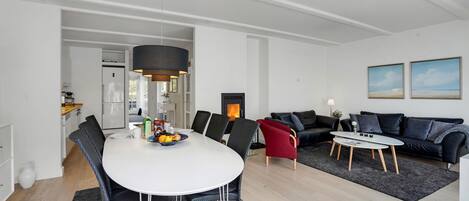 Un salon moderne comprenant un coin repas, une cheminée et un ensemble de canapés.