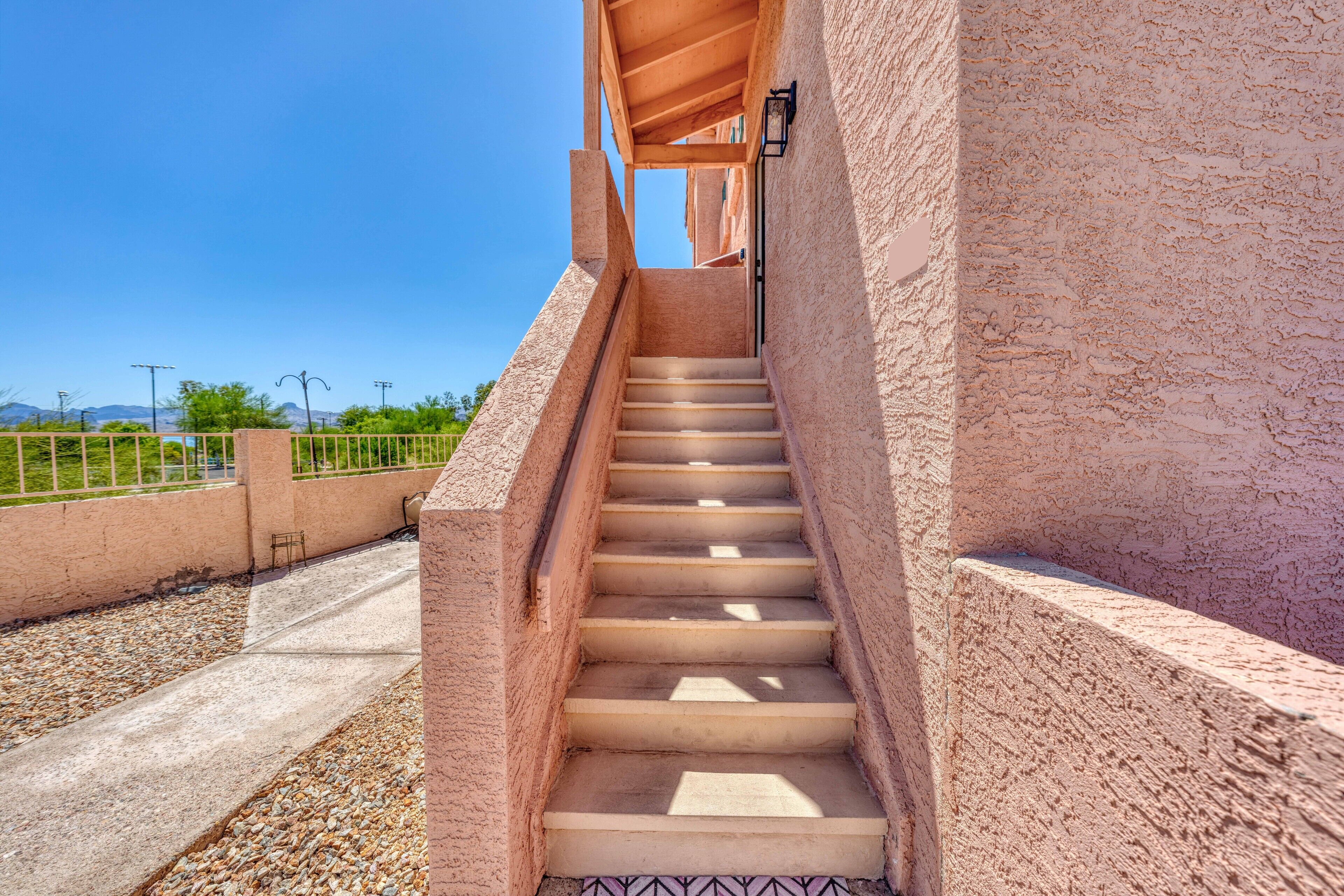 Un escalier menant à un balcon d’où l’on peut admirer le ciel et les montagnes lointaines.