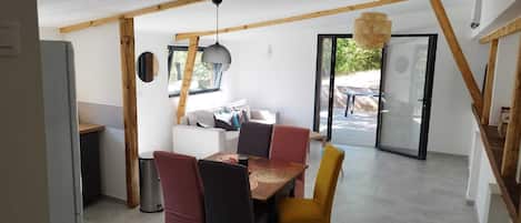 A modern interior with a dining area, a sofa, and a window.