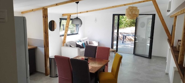 A modern interior with a dining area, a sofa, and a window.