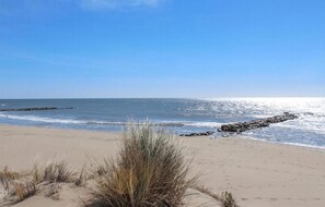 A beach with a clear sky, waves, and a rocky breakwater. - Beautiful home in Moulès (Moulès)