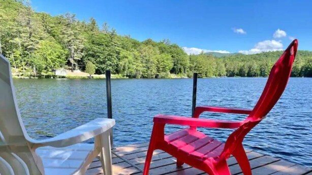 Two chairs on a wooden dock by a lake with a forested background. - Lakeside Haven - Ice fishing, Snowmobiling, Skiing (Denmark)