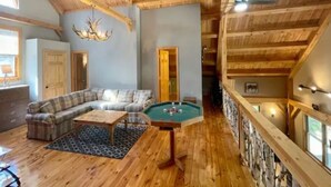 A wooden interior with a pool table, a sofa, and a chandelier. - Lakeside Haven - Ice fishing, Snowmobiling, Skiing (Denmark)