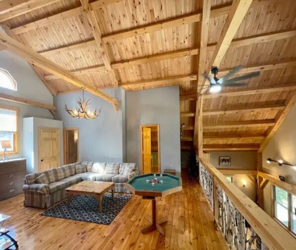 Un interno in legno con tavolo da biliardo, divano e lampadario.