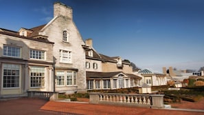 A large, historic building with multiple windows and a brick pathway.