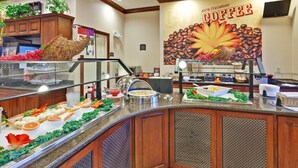 A buffet area with a coffee-themed backdrop, a variety of food items, and a coffee machine. - Suite Near Rochester University | Gym Access (Rochester)