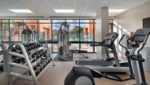 A gym with treadmills, dumbbells, and weight machines. - Comfy Studio Suite | Free Breakfast + Outdoor Pool (San Antonio)